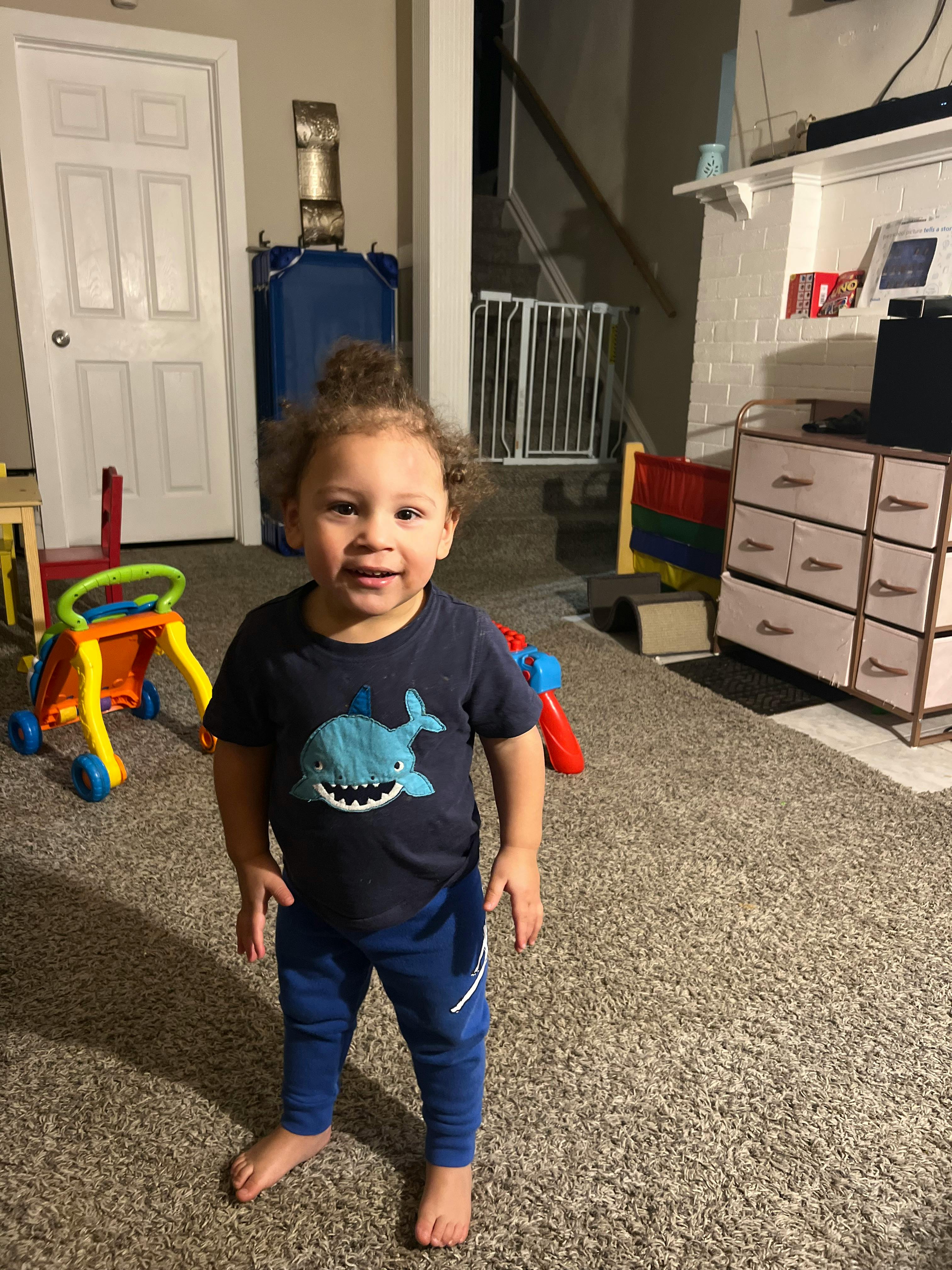 Child standing in a room with toys