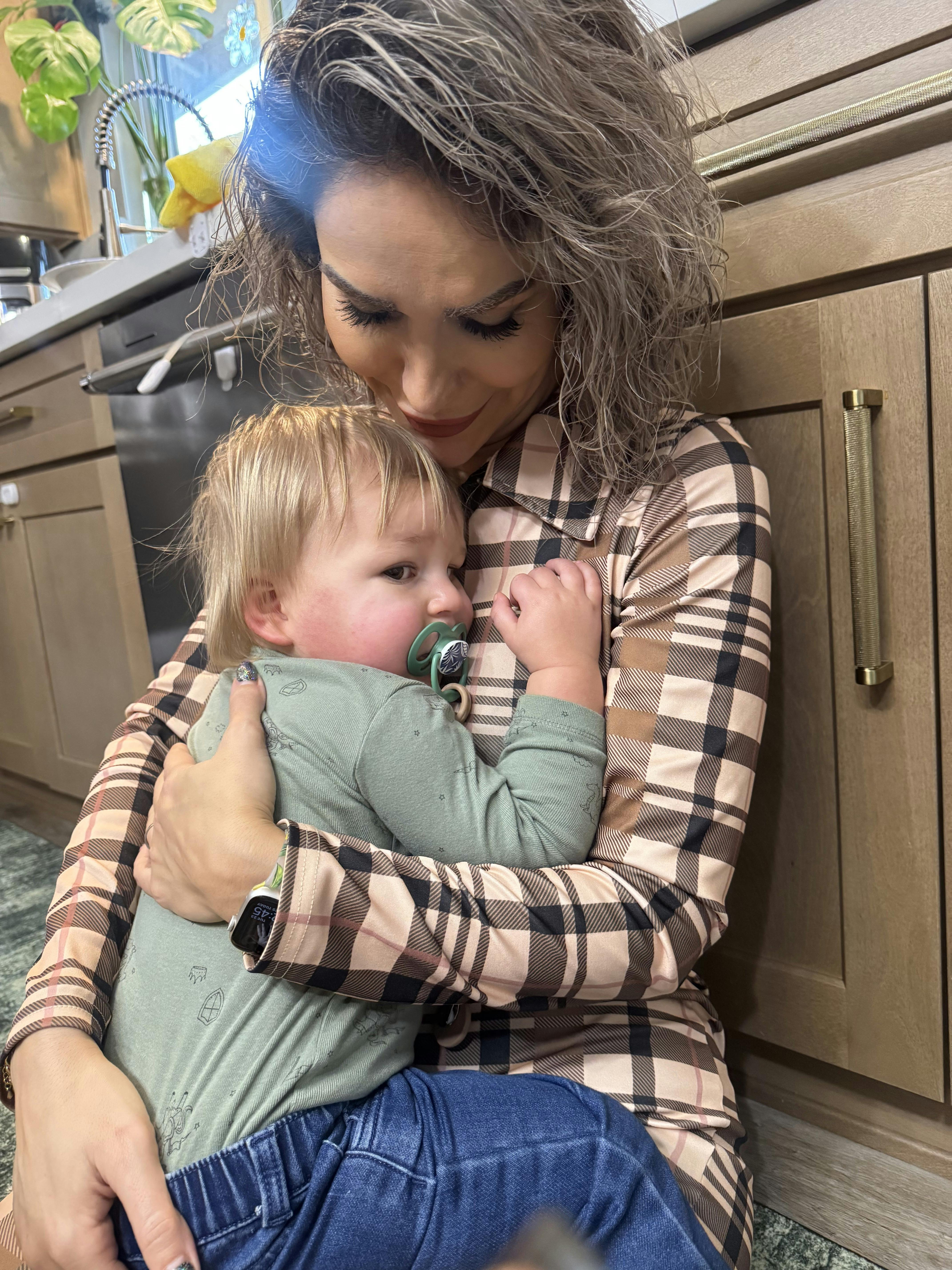 Person holding a child with a pacifier