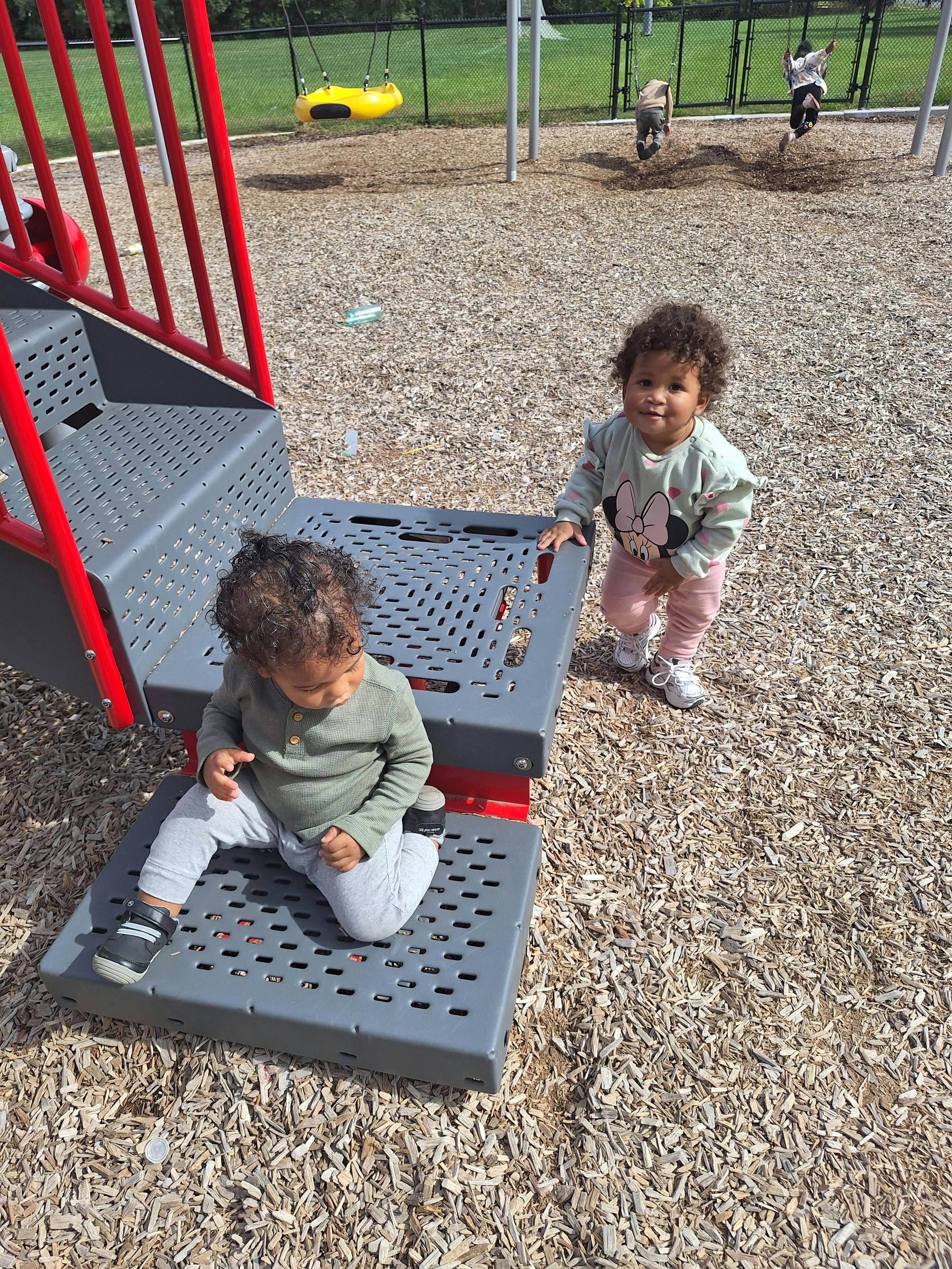 Two children playing on a playground structure