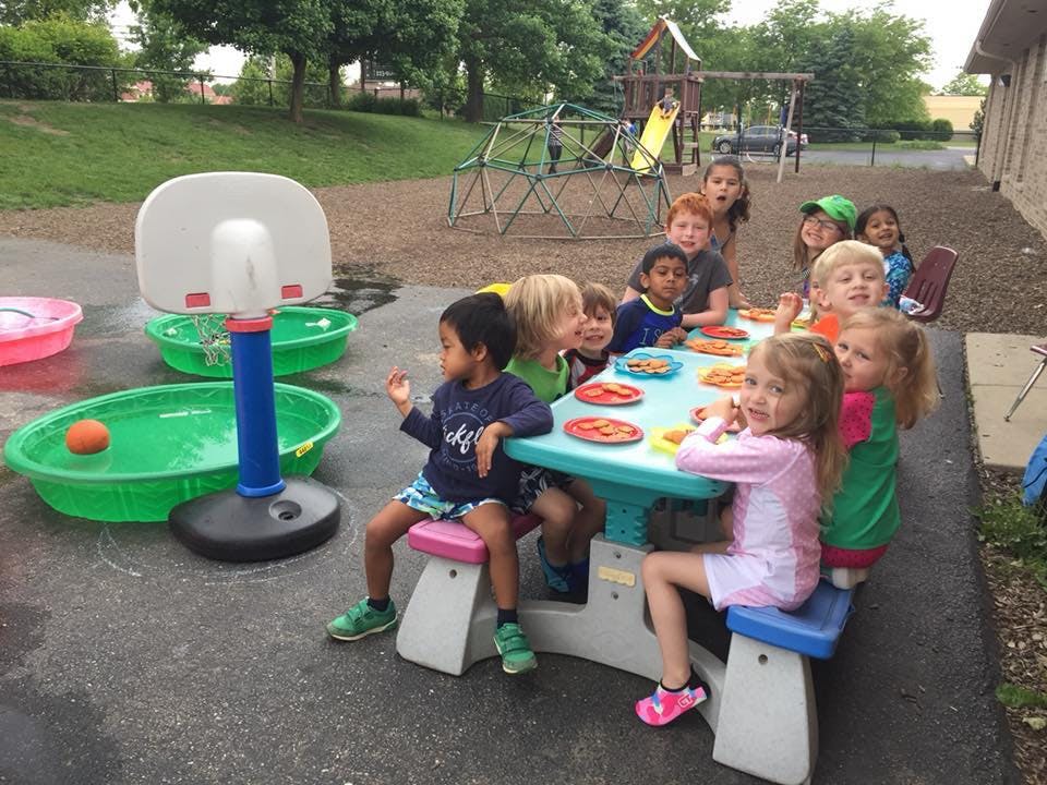 Children sitting at a picnic table outdoors