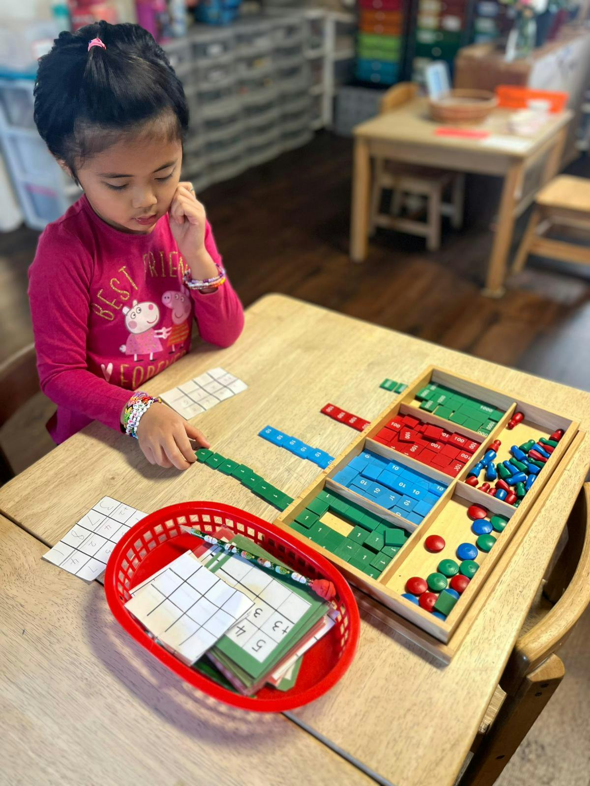 Child playing with colorful learning blocks and cards at a table