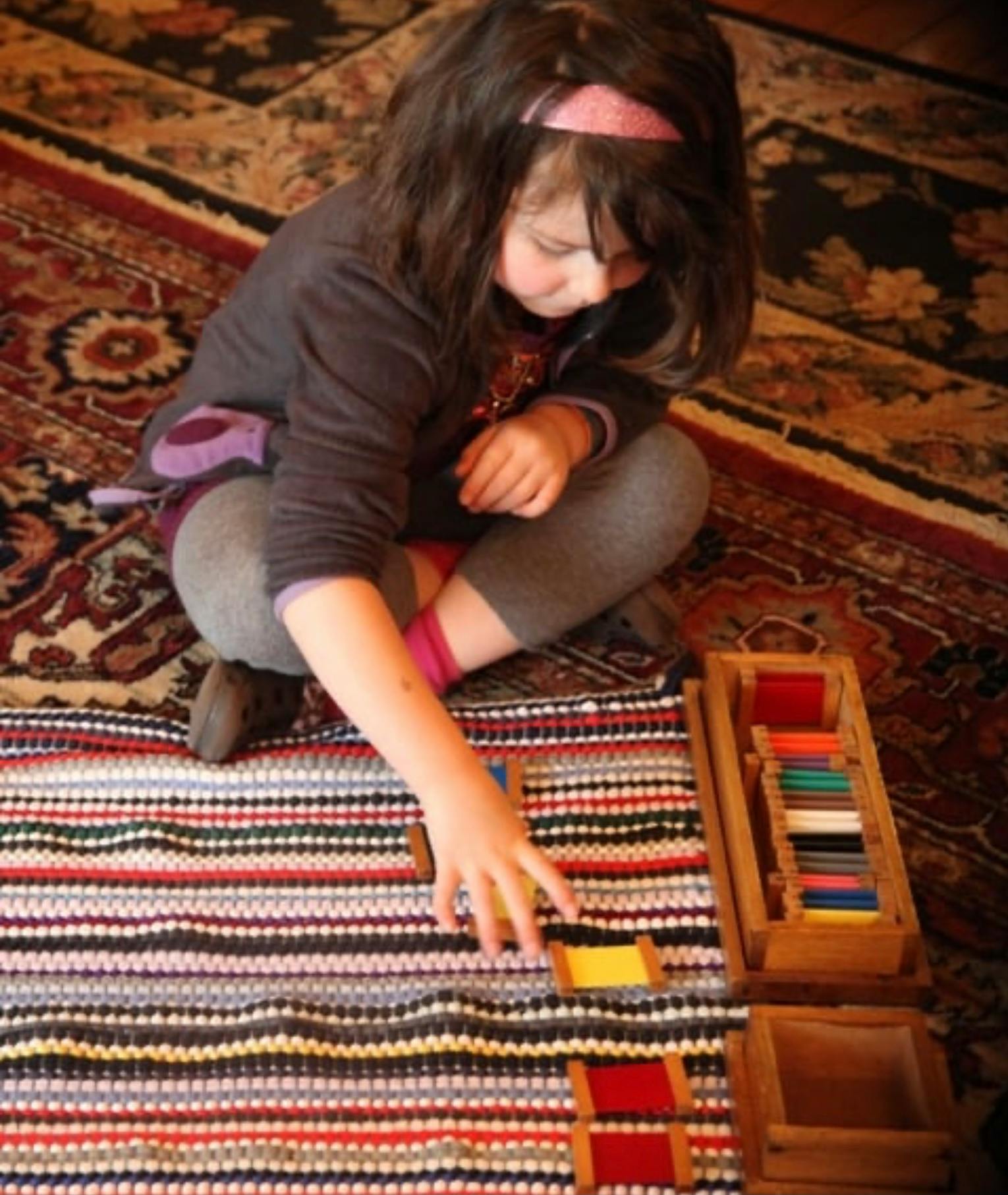 Child playing with colorful blocks on a patterned rug