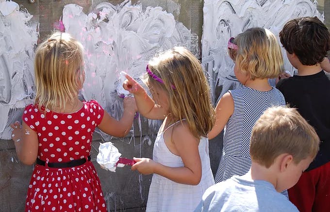 Children painting with white paint