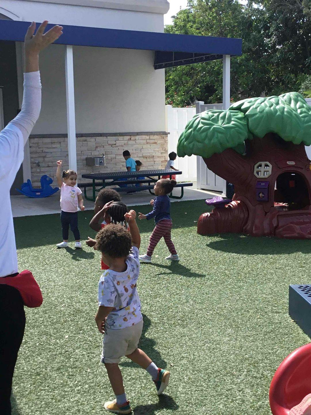 Children playing on a playground with a tree-shaped play structure