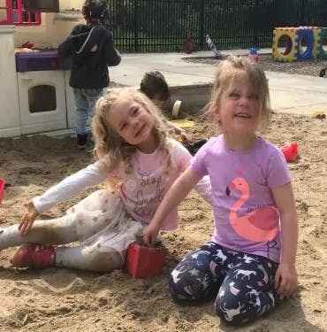 Two children sitting in a sandbox