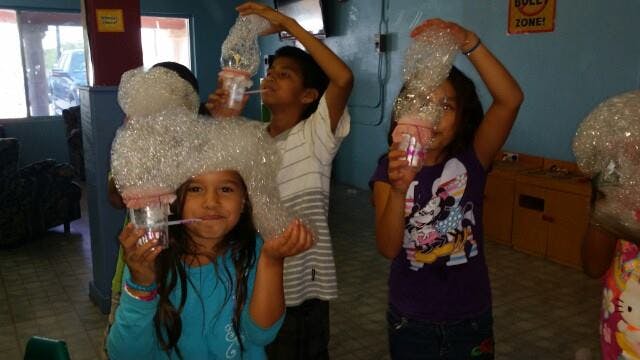 Children making bubbles with plastic bottles