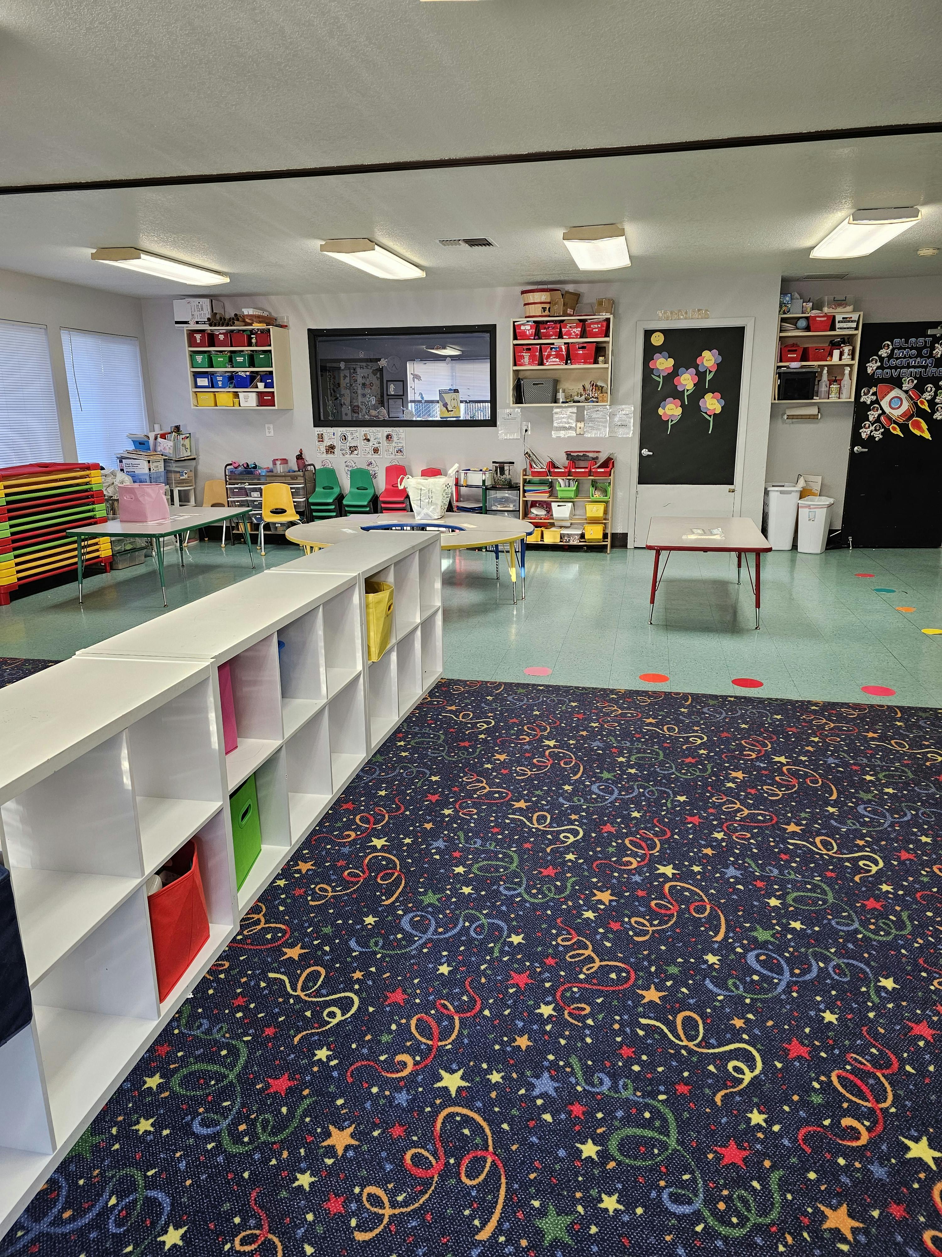 Empty classroom with colorful carpet and storage shelves