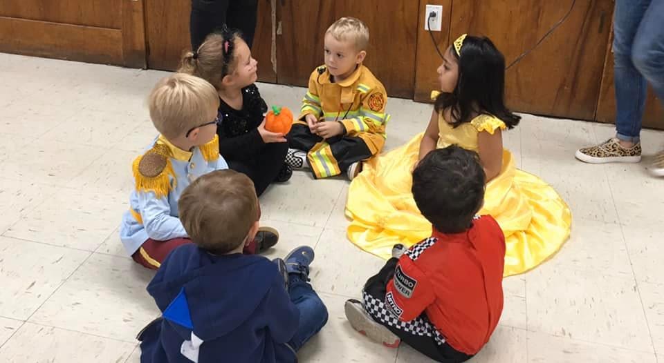 Children in costumes sitting in a circle