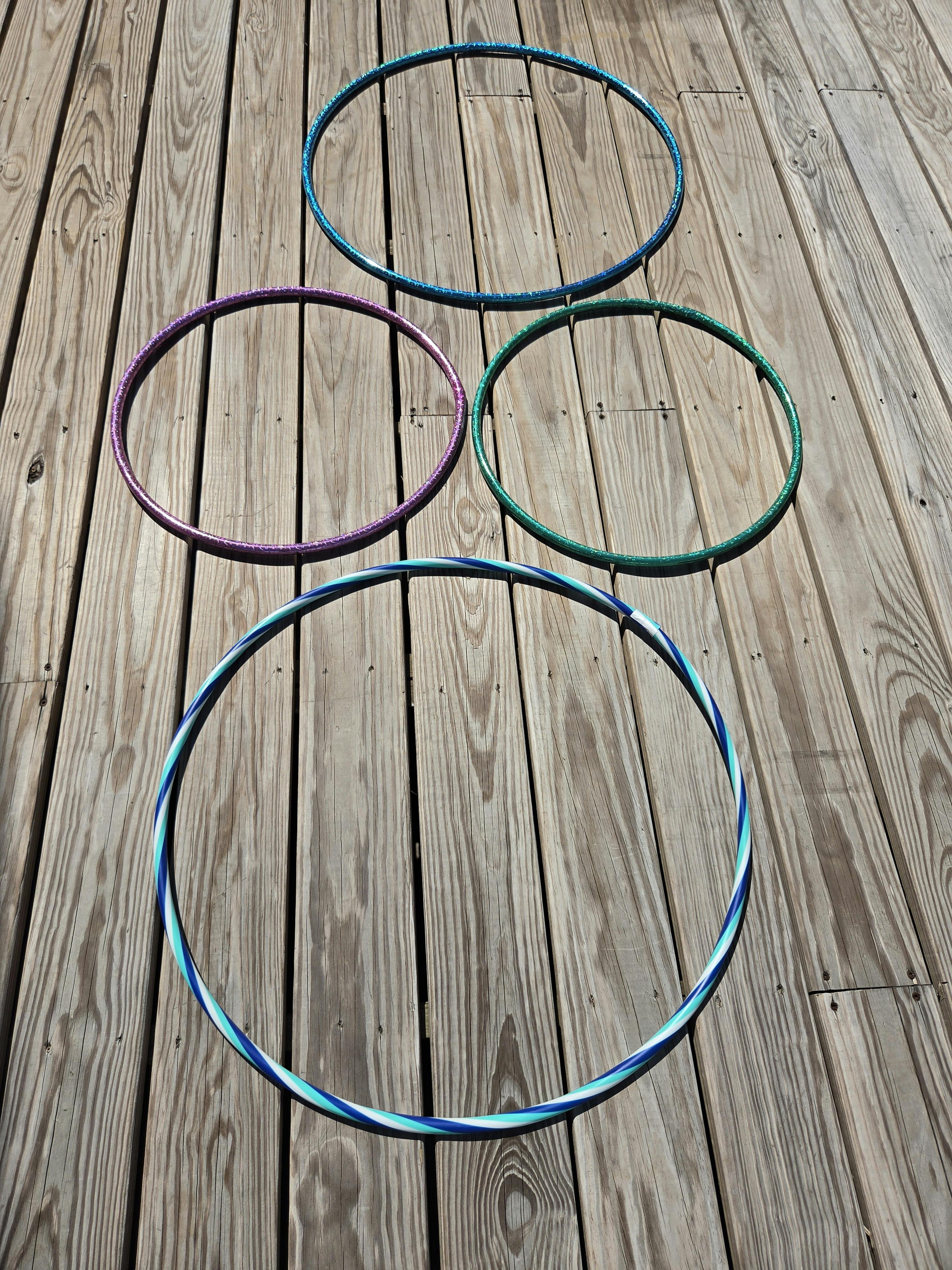 Four hula hoops arranged on a wooden deck