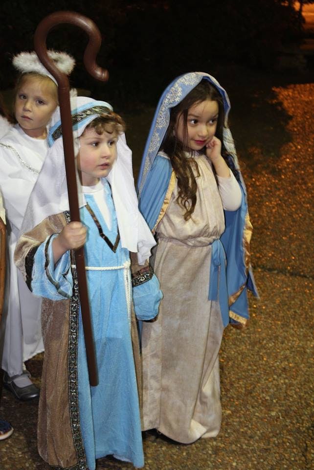 Three children in costumes, one holding a shepherd's crook