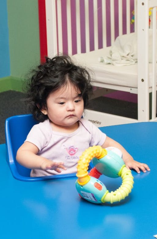 Child sitting at a table with a toy