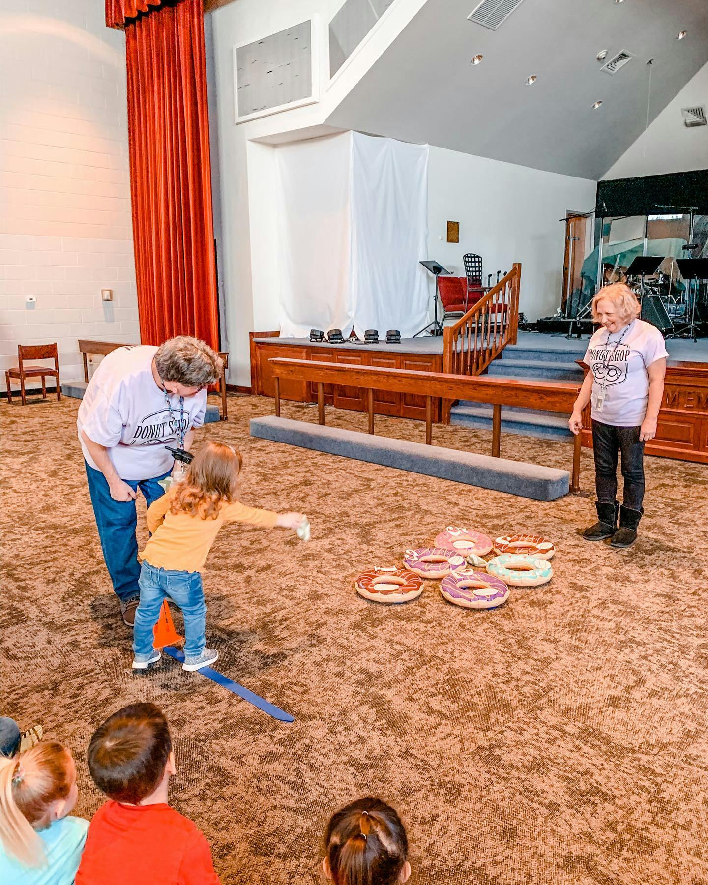Adult and child playing a ring toss game indoors