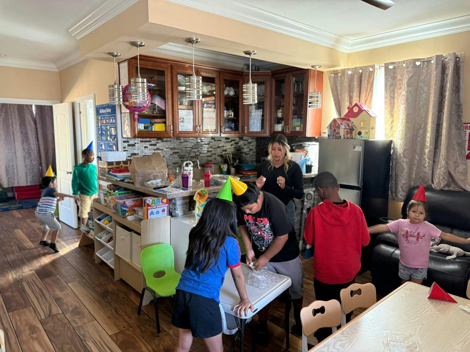 Group of children wearing party hats in a kitchen