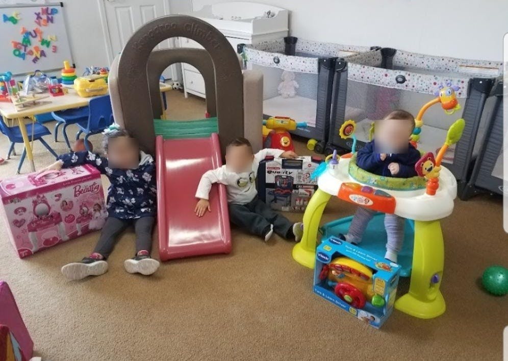 Three children playing with toys in a room