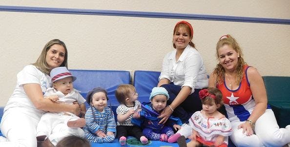 Three people sitting with five children