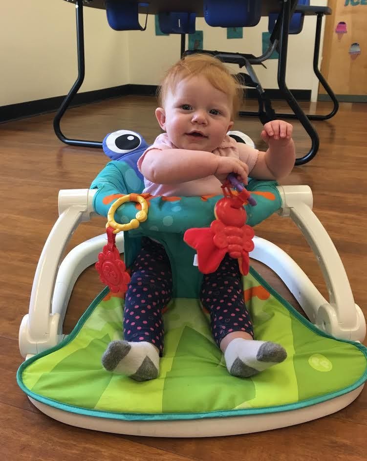 Child in a baby seat with toys