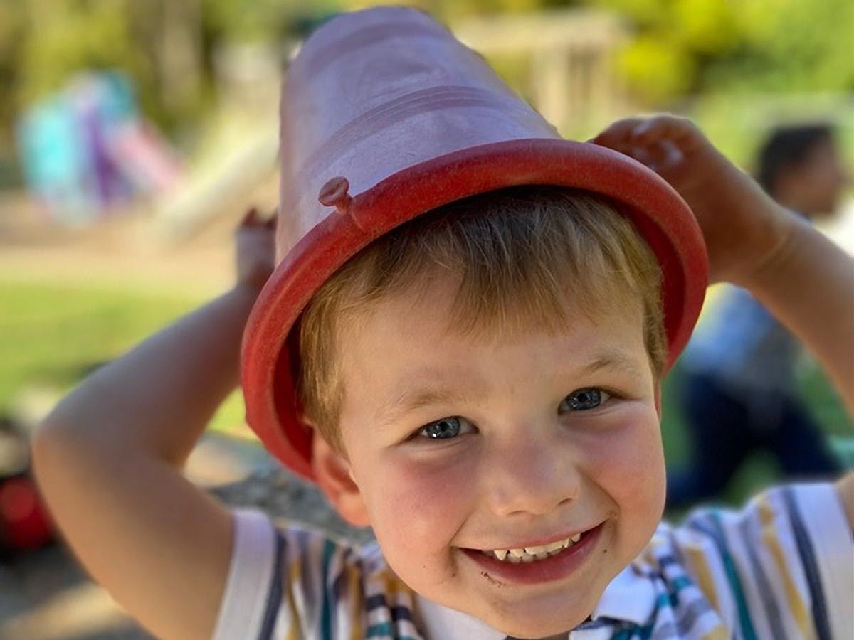 Child wearing a bucket on their head