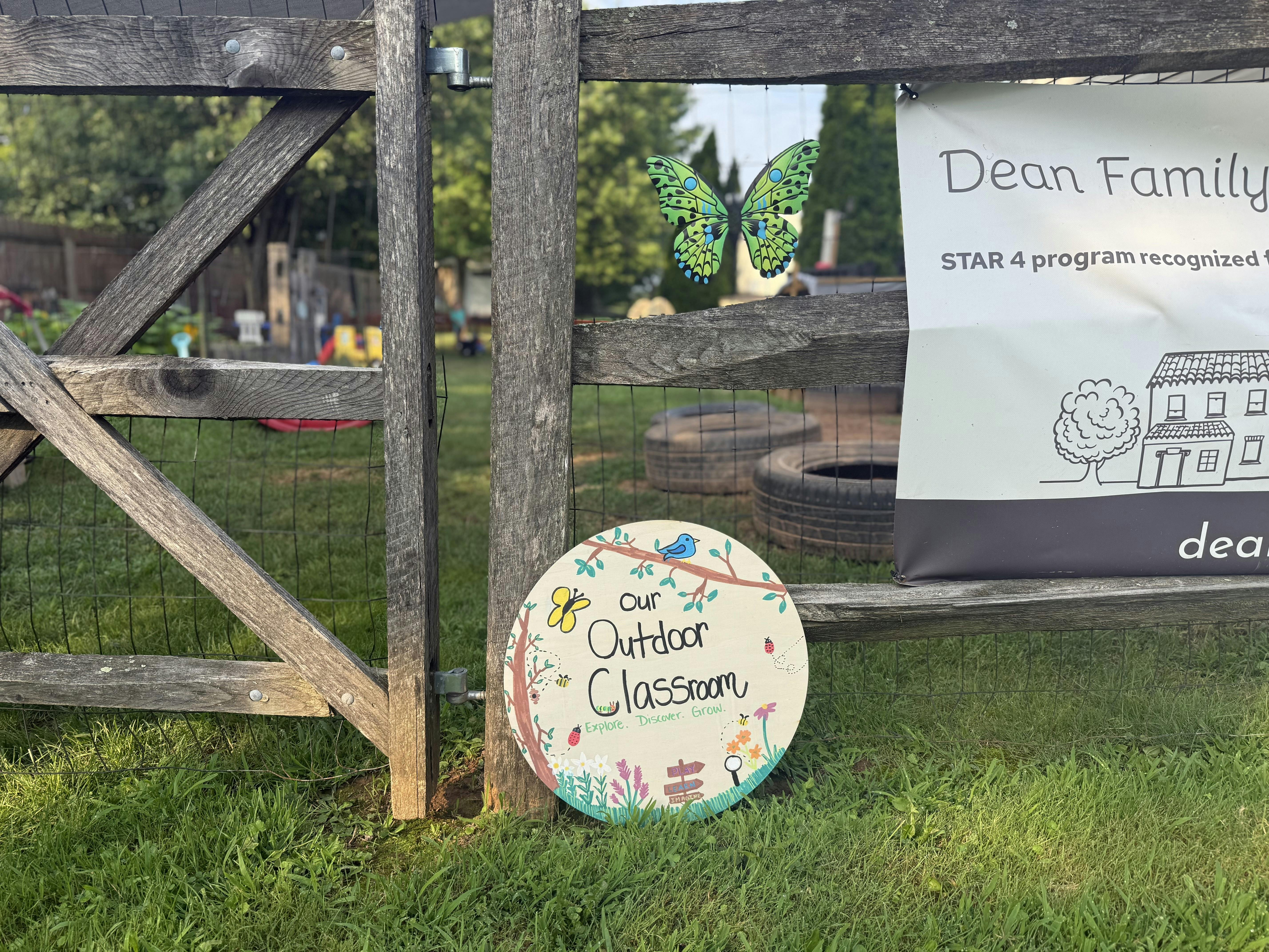 Wooden gate and sign reading our outdoor classroom in a grassy area