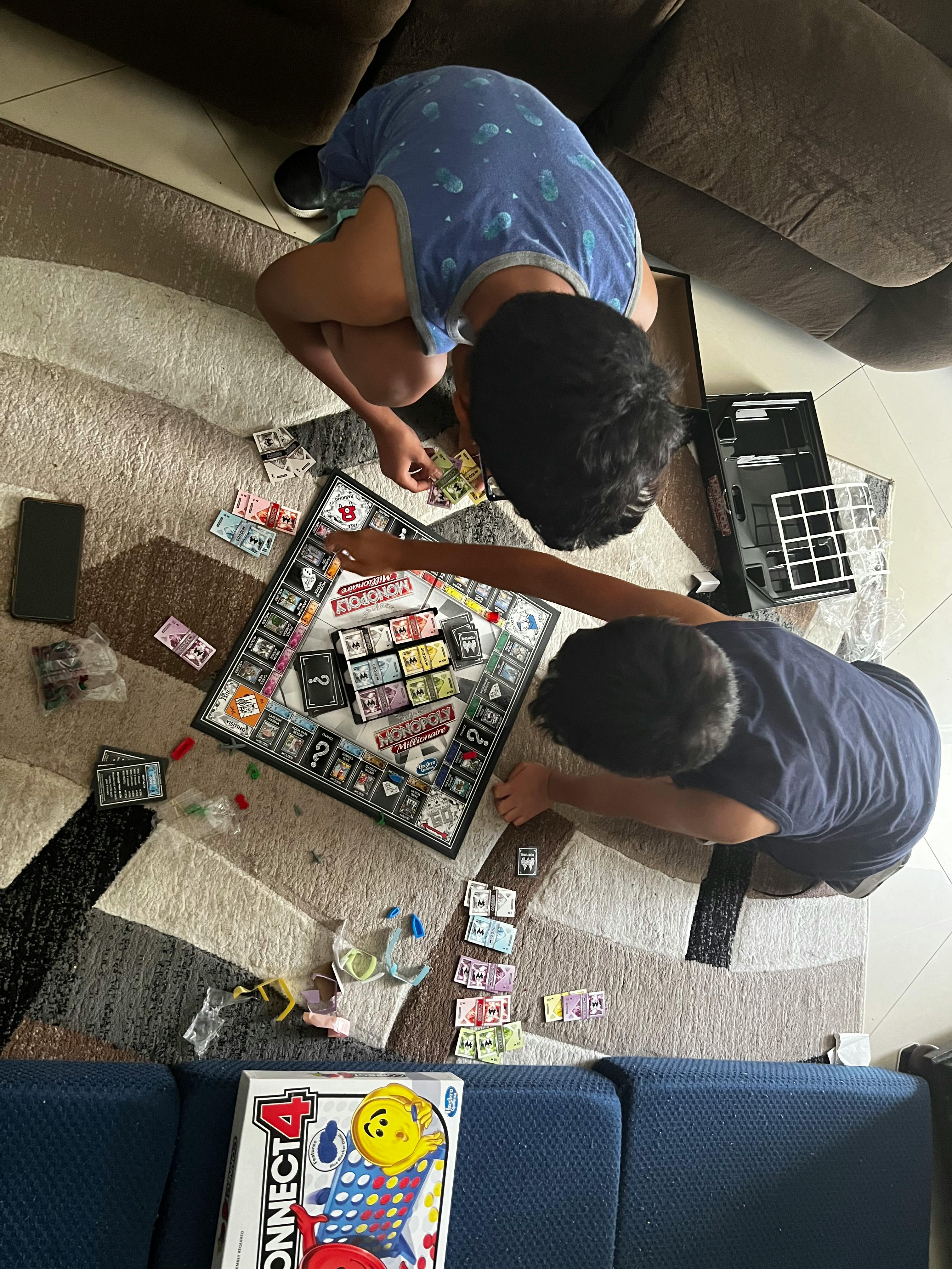 Two people playing a board game on the floor