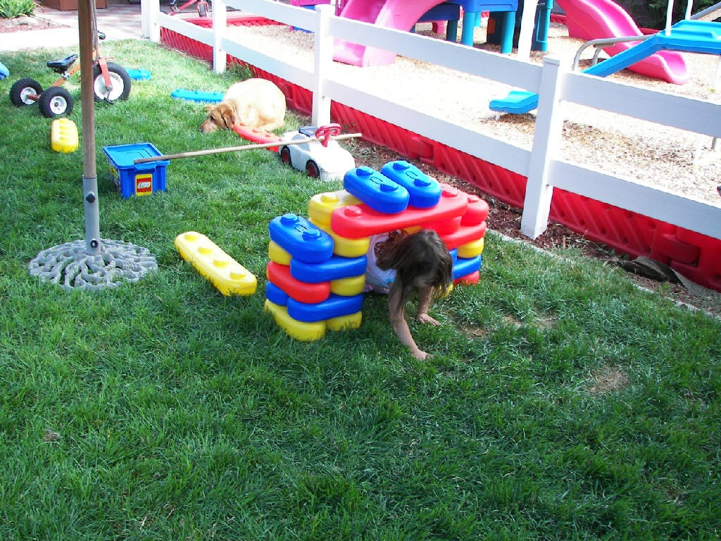 Child playing with colorful blocks on grass
