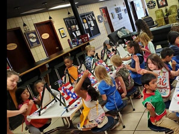 Children painting at easels in a classroom
