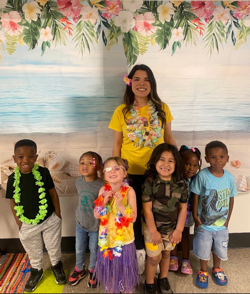 Adult and multiple children in front of a beach-themed backdrop