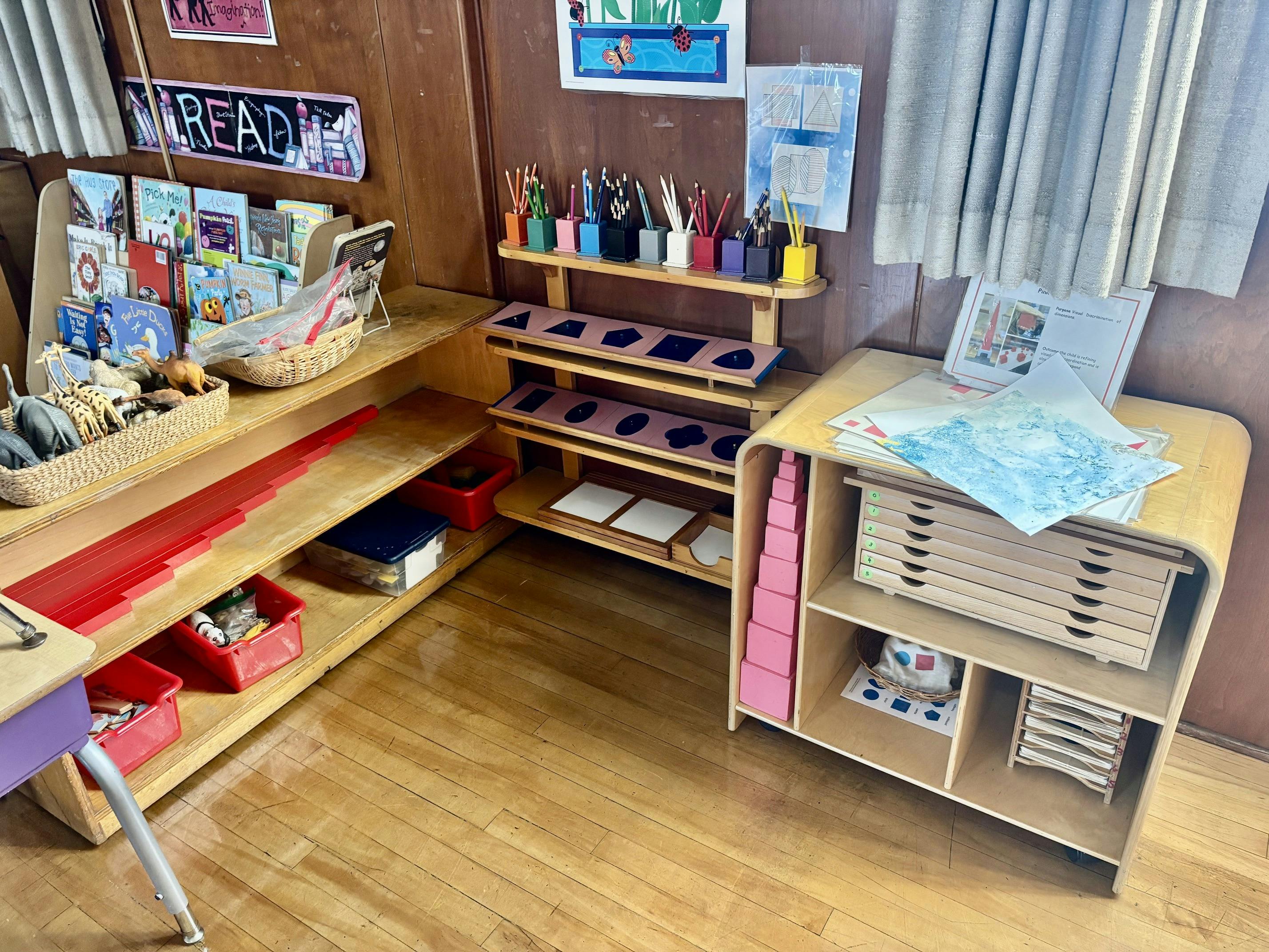 Wooden shelves with children's books and educational materials in a classroom