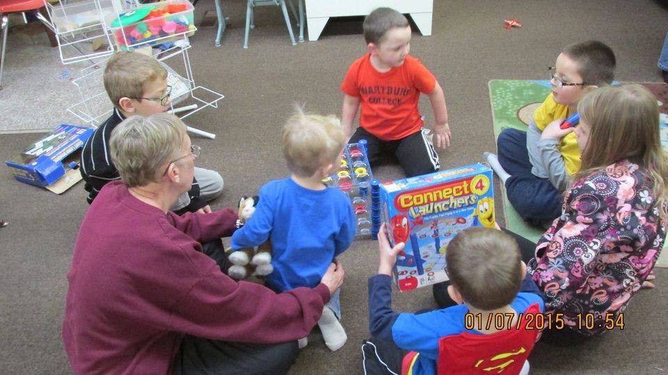Adult and children playing a board game on the floor