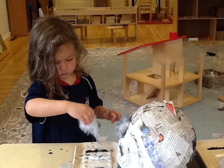 Child working on a paper mache project