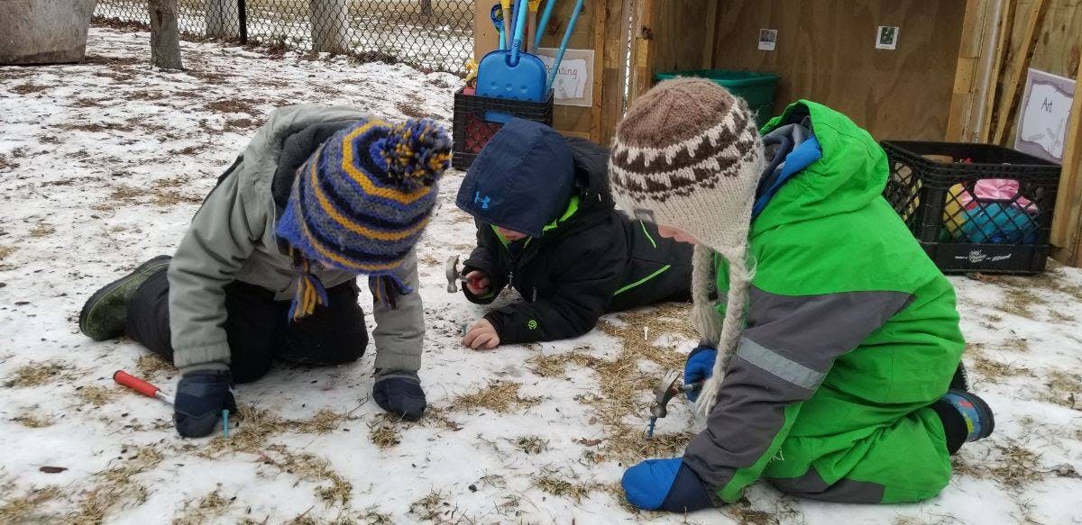 Three children kneeling in snow