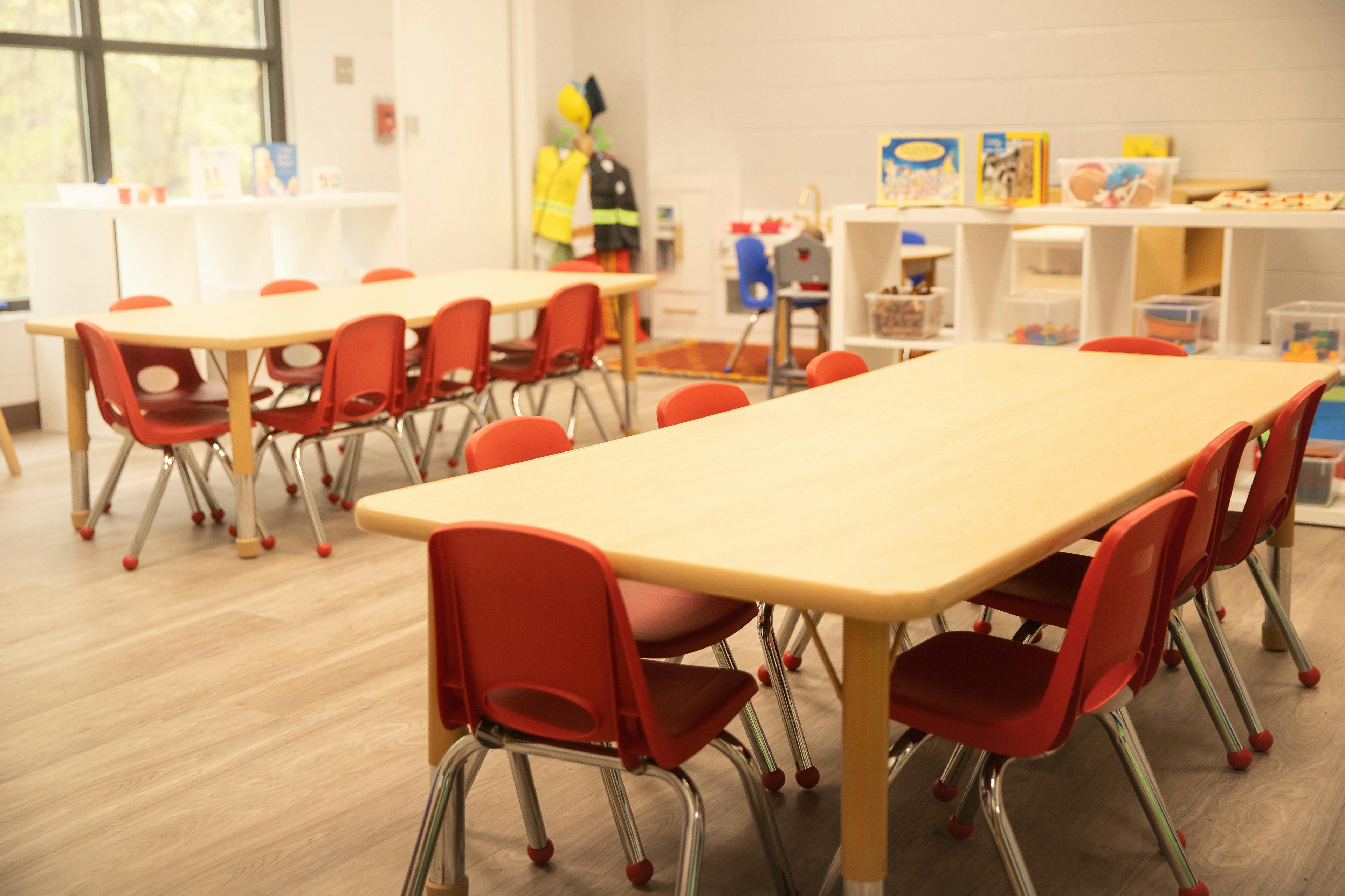 Classroom with two long tables and red chairs