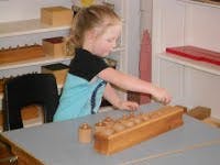 Child playing with wooden educational toy at a table