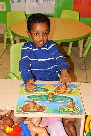 Child playing with a wooden animal puzzle