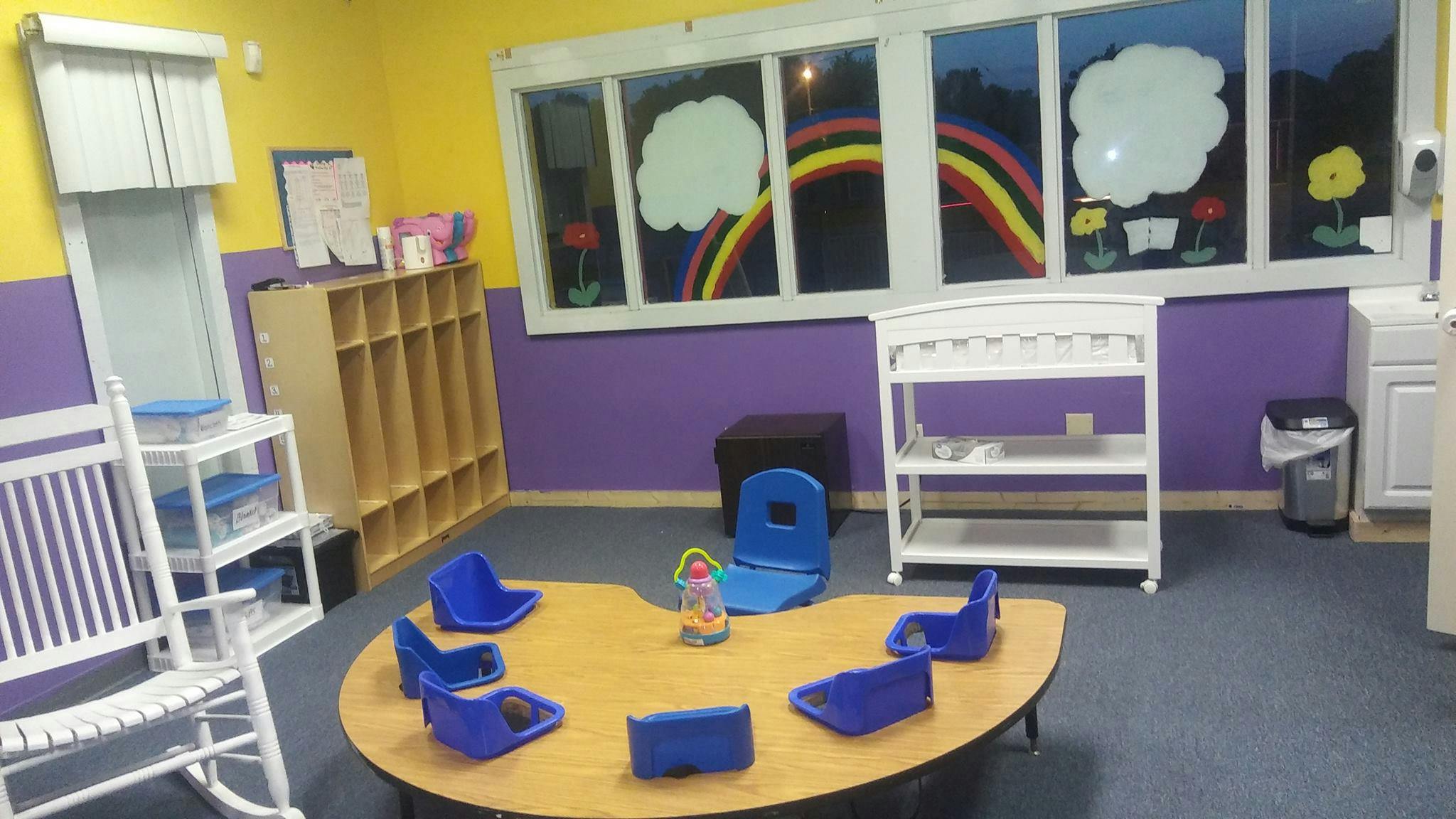 Classroom with small table and chairs, storage, and window decorations