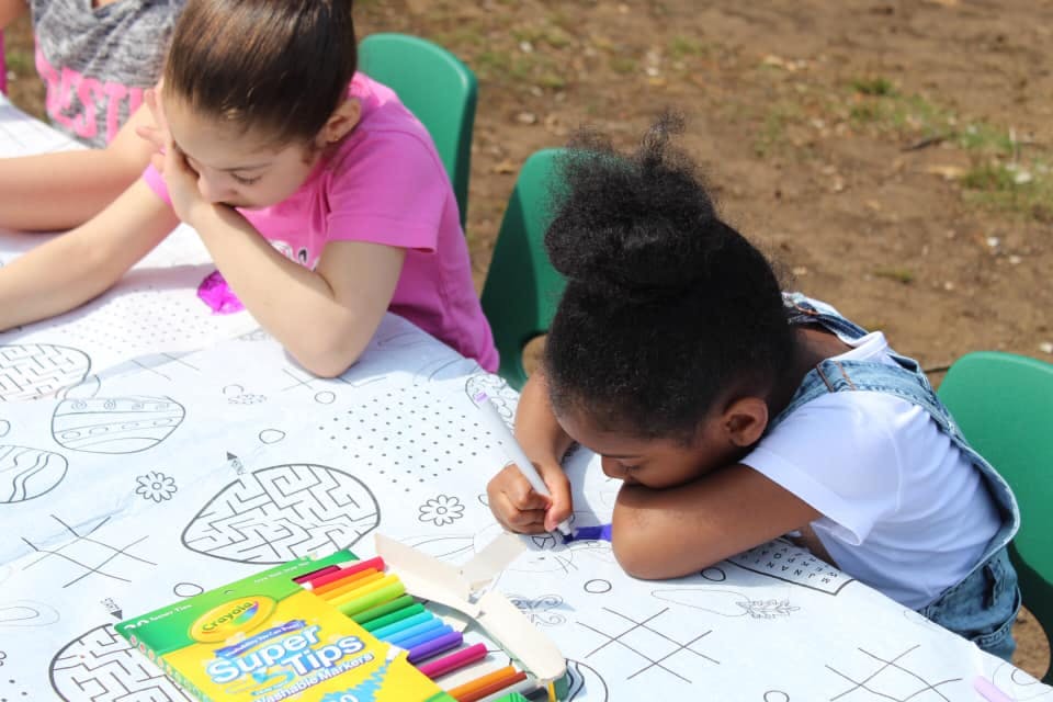Two children coloring at a table with markers