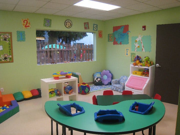 Playroom with green walls, colorful furniture, and toys