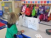 Child playing with paper bags in a classroom