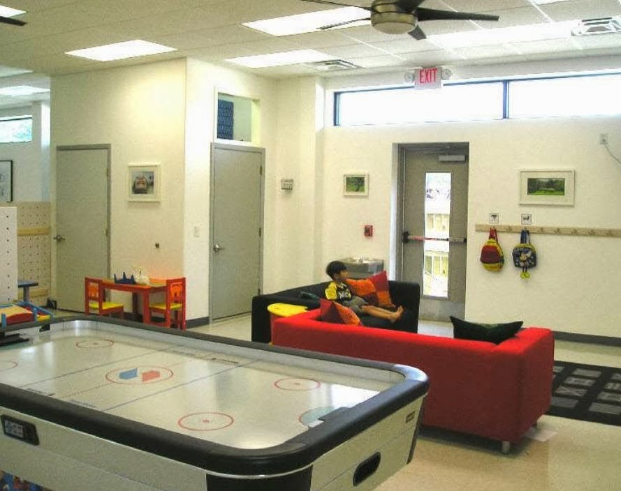 Air hockey table in foreground, person on a couch in the background