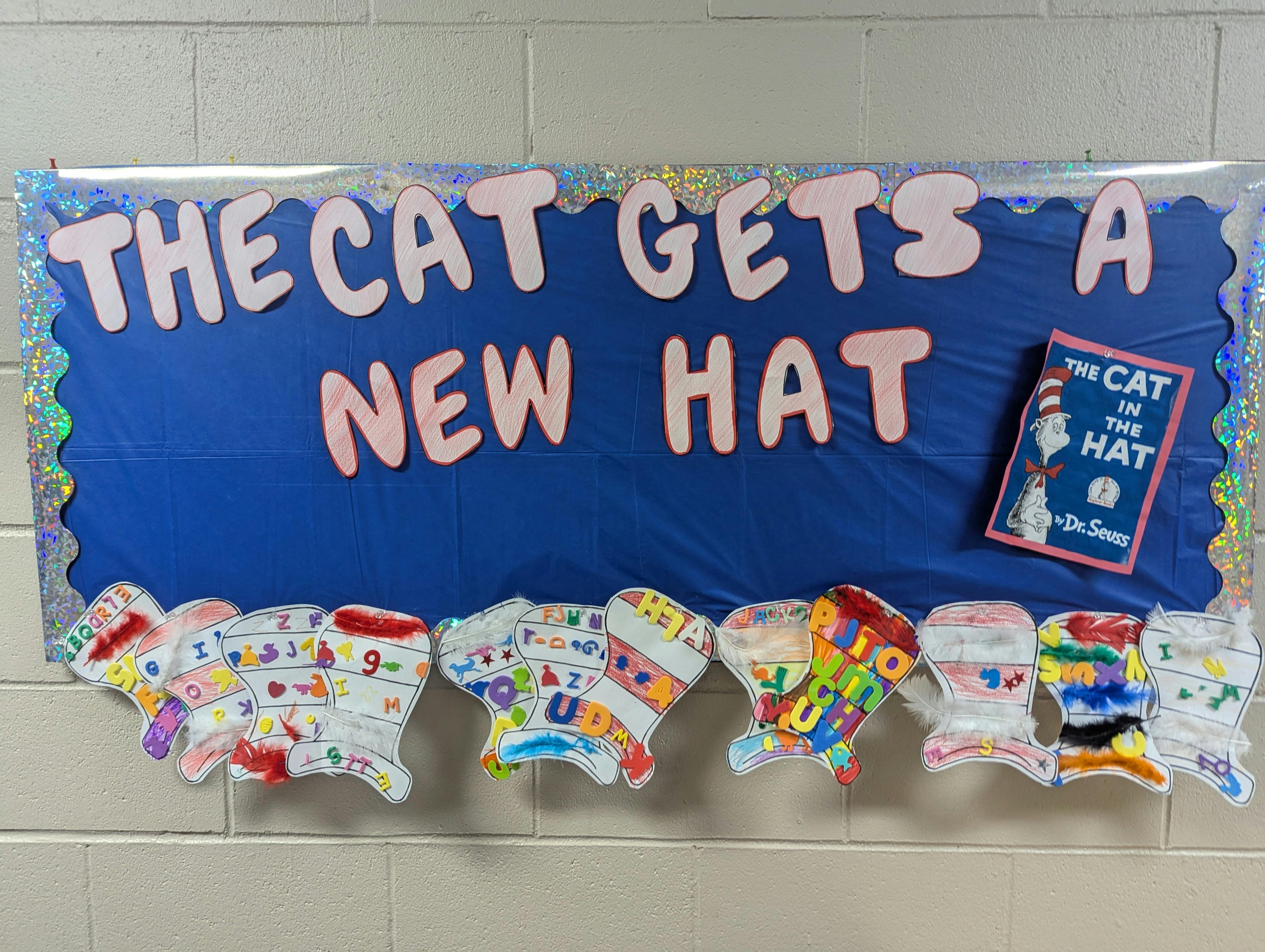Bulletin board with "The Cat Gets a New Hat" and paper hats below