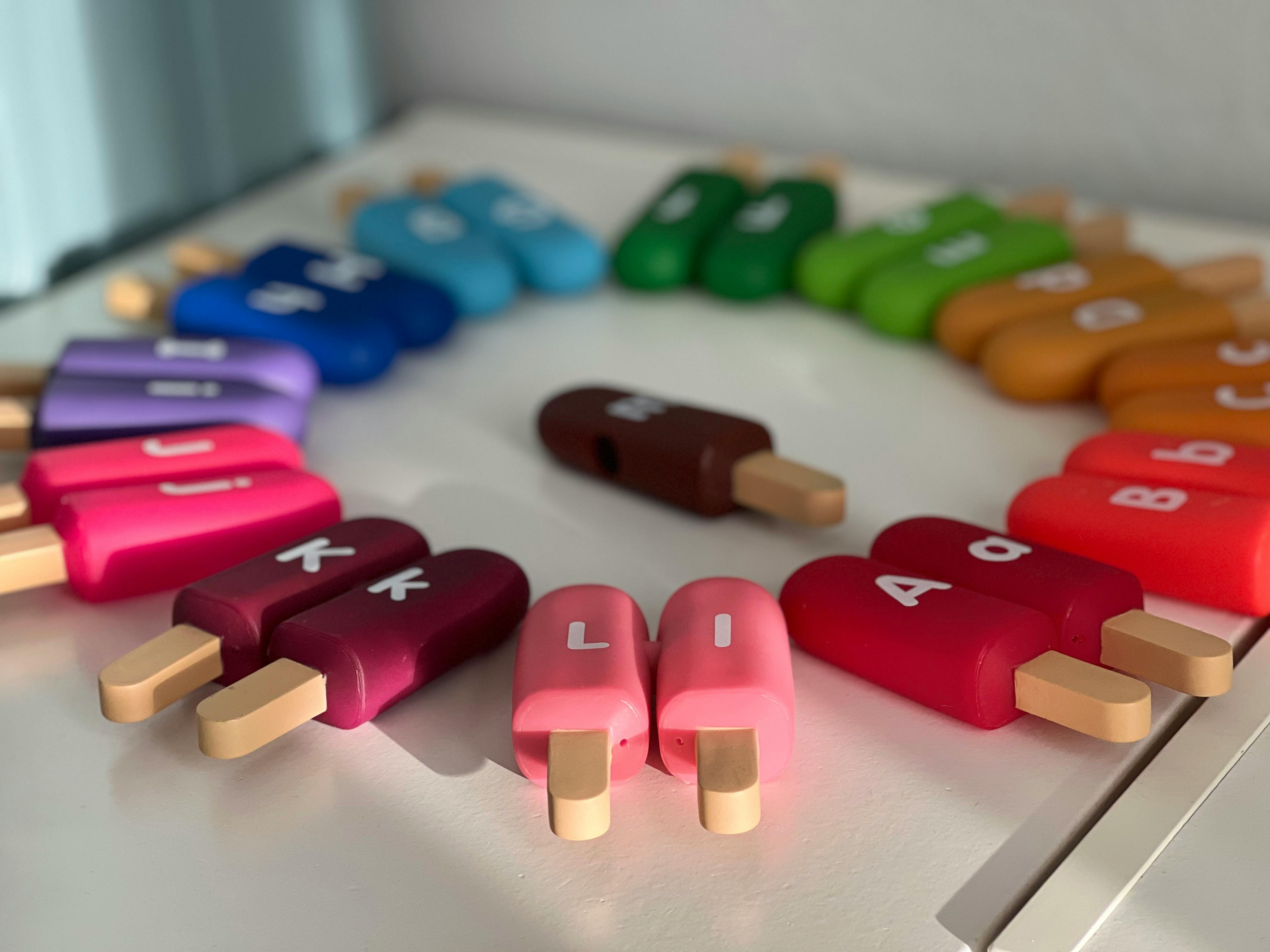 Colorful popsicle-shaped learning toys with letters and numbers