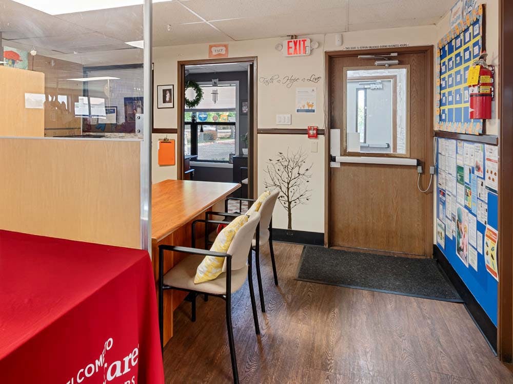 Reception area with a counter, chairs, and bulletin board