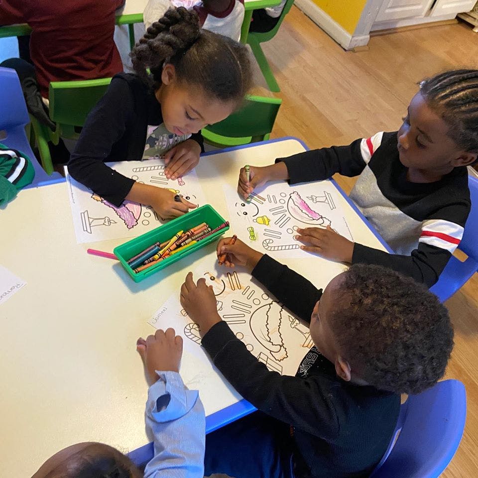 Children coloring at a table in a classroom