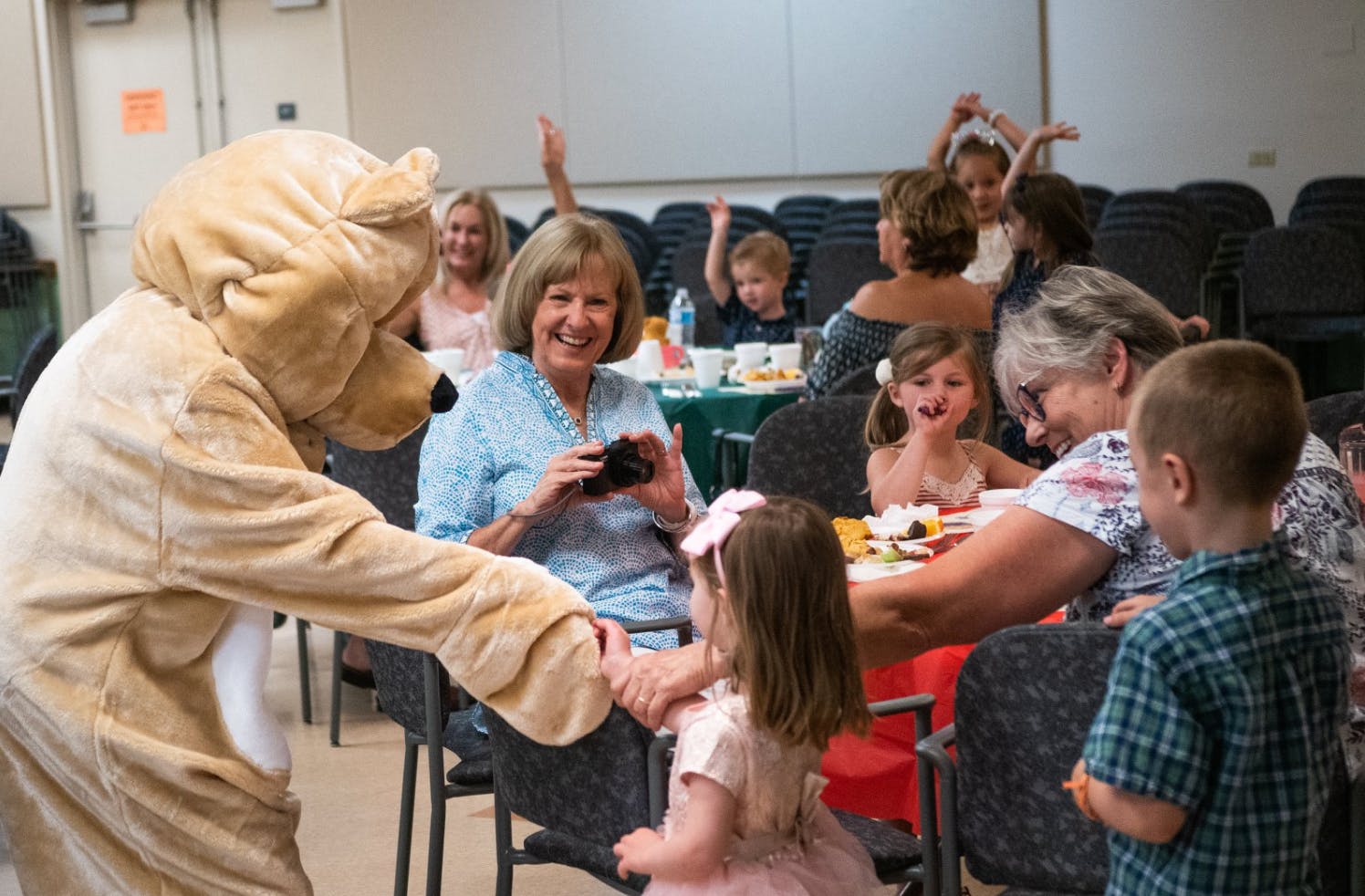 Person in mascot costume shaking hands with a child