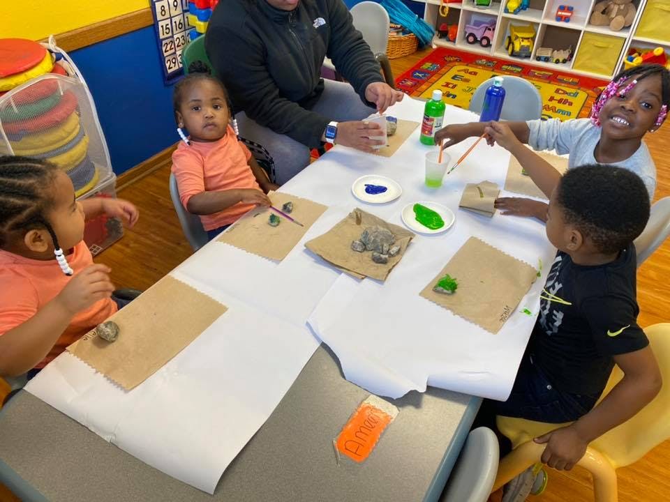 Adult and children painting at a table