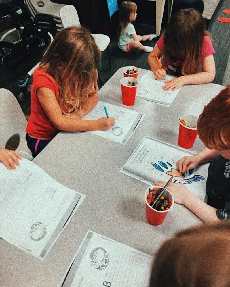 Children drawing and writing at a table