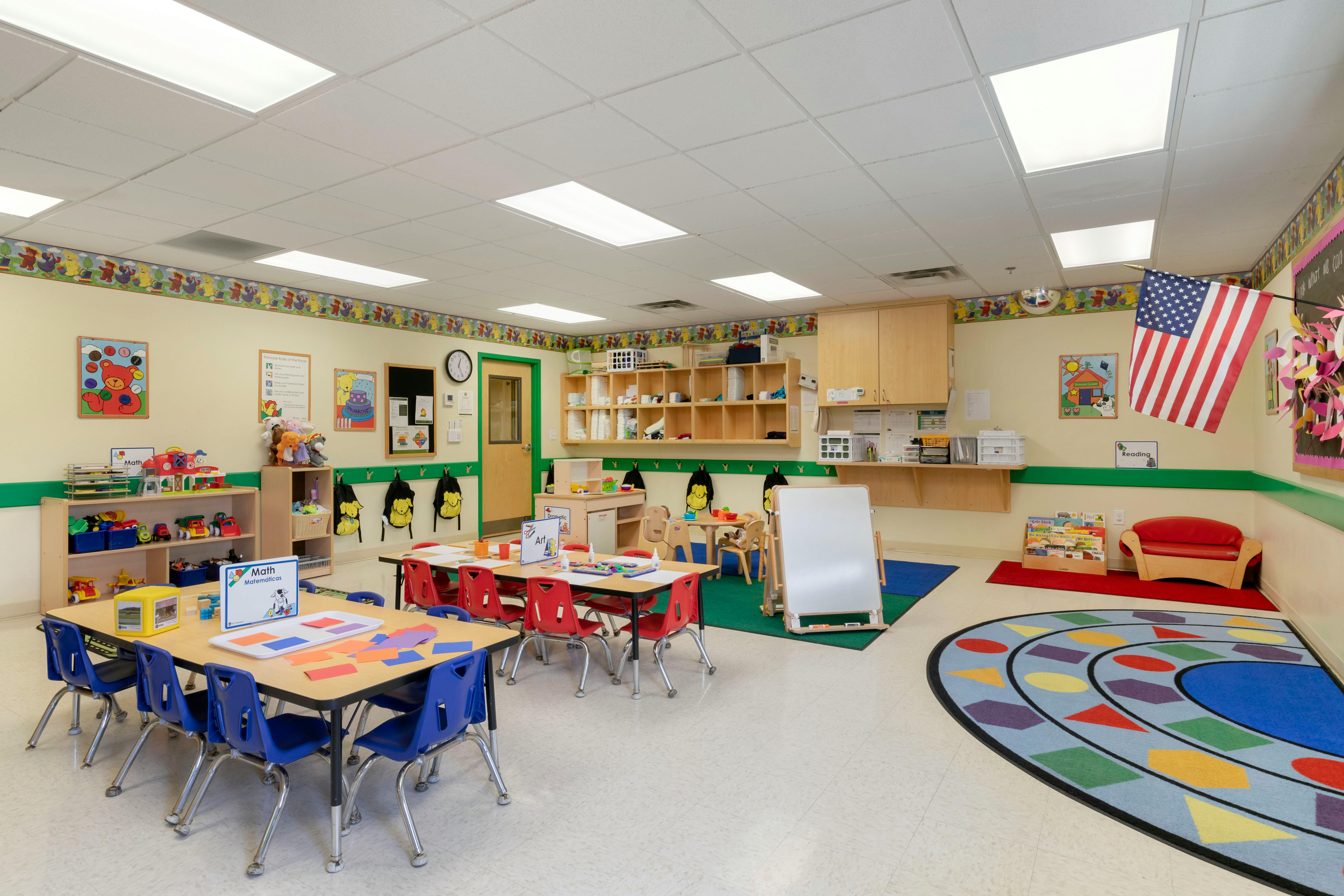 Empty colorful children's classroom with small tables and chairs