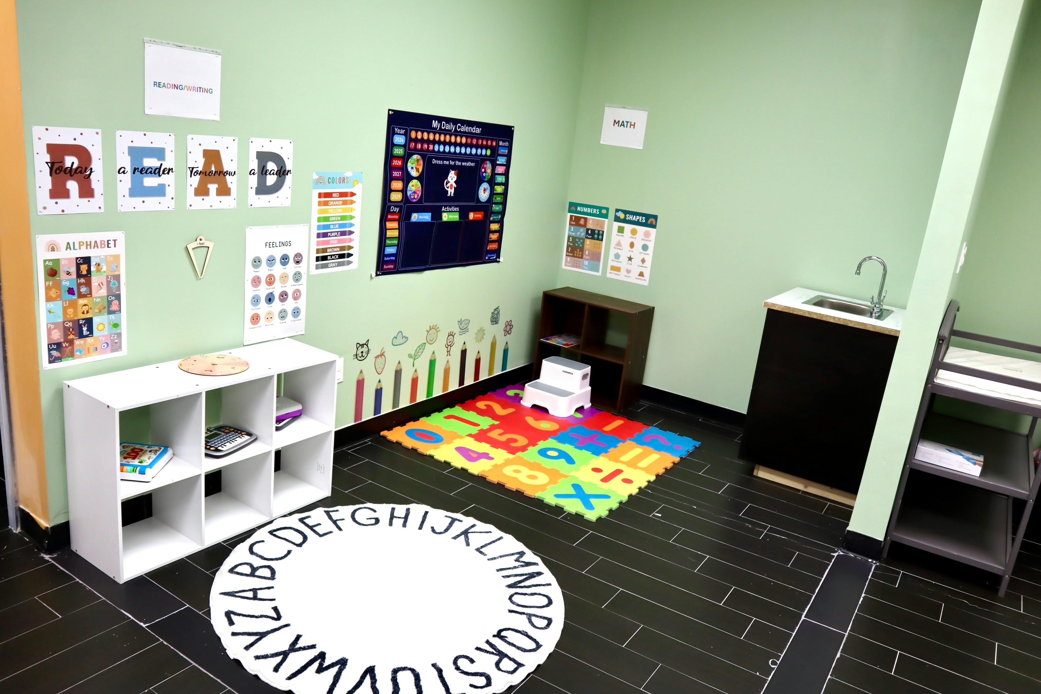 Classroom with alphabet rug, colorful playmat, and educational posters