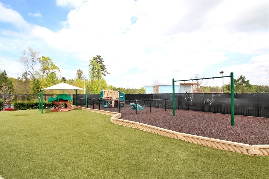 Outdoor playground with swings, slides, and artificial turf
