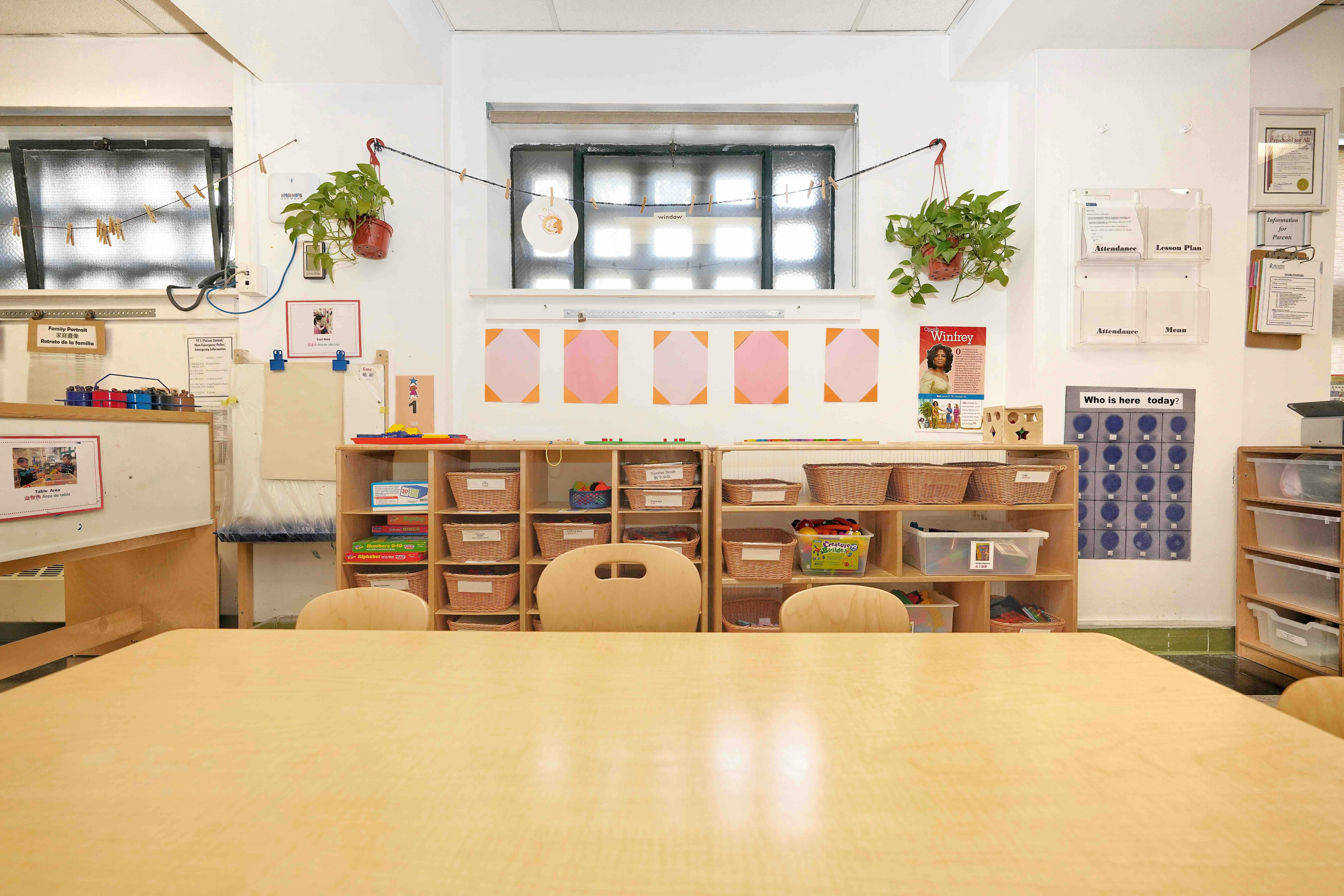 Classroom interior with wooden storage shelves filled with baskets and learning toys