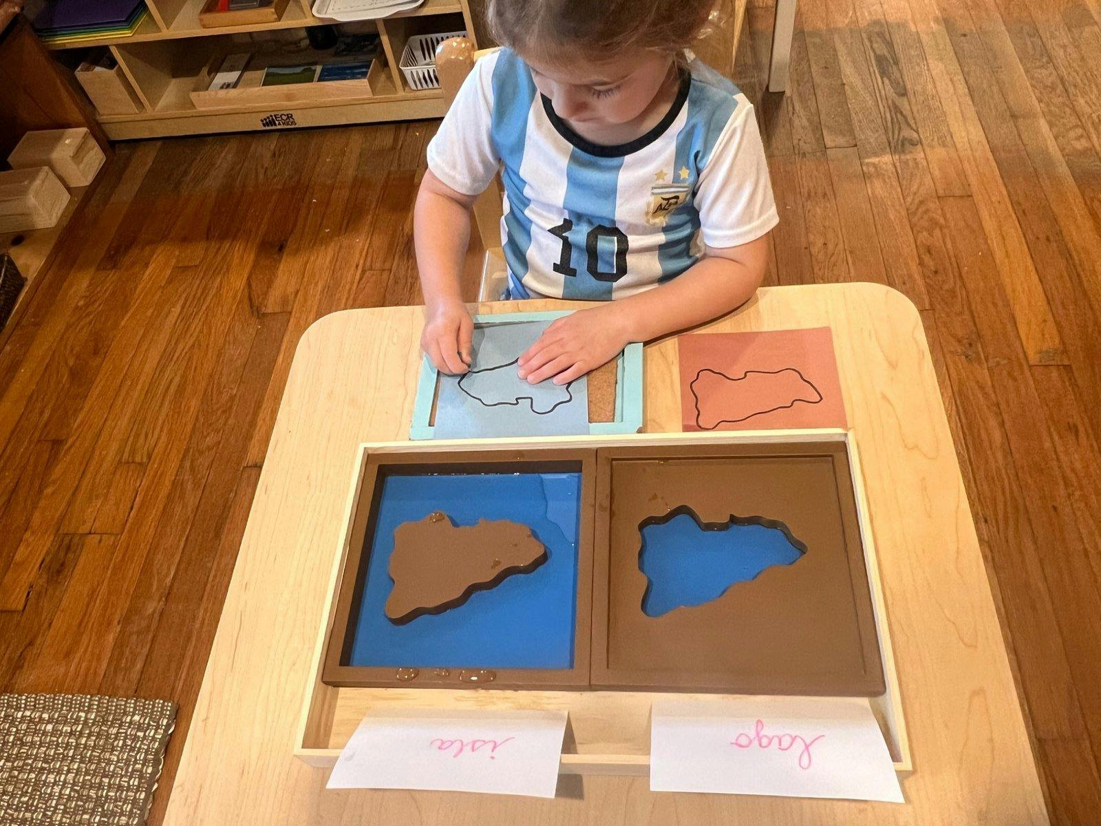 Child placing a map puzzle piece on a table